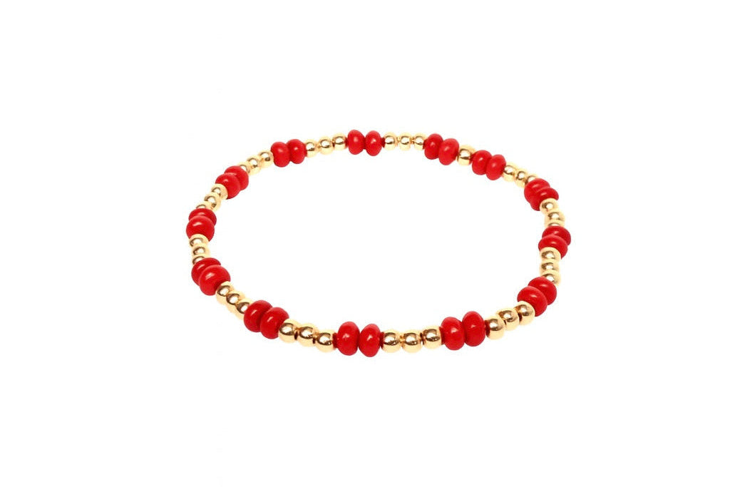 Bracelet with red beads and gold accents on a white background